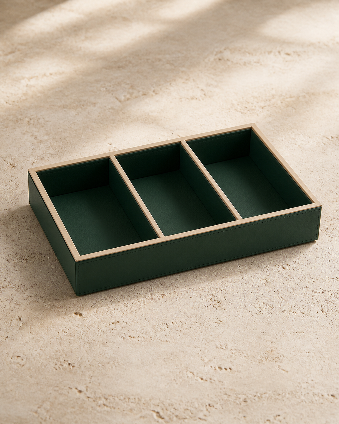 Green compartment tray with beige piping, 3 compartments, grounded editorial view