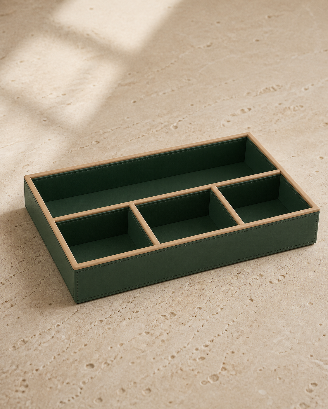 Green compartment tray with beige piping, 4 compartments, grounded editorial view