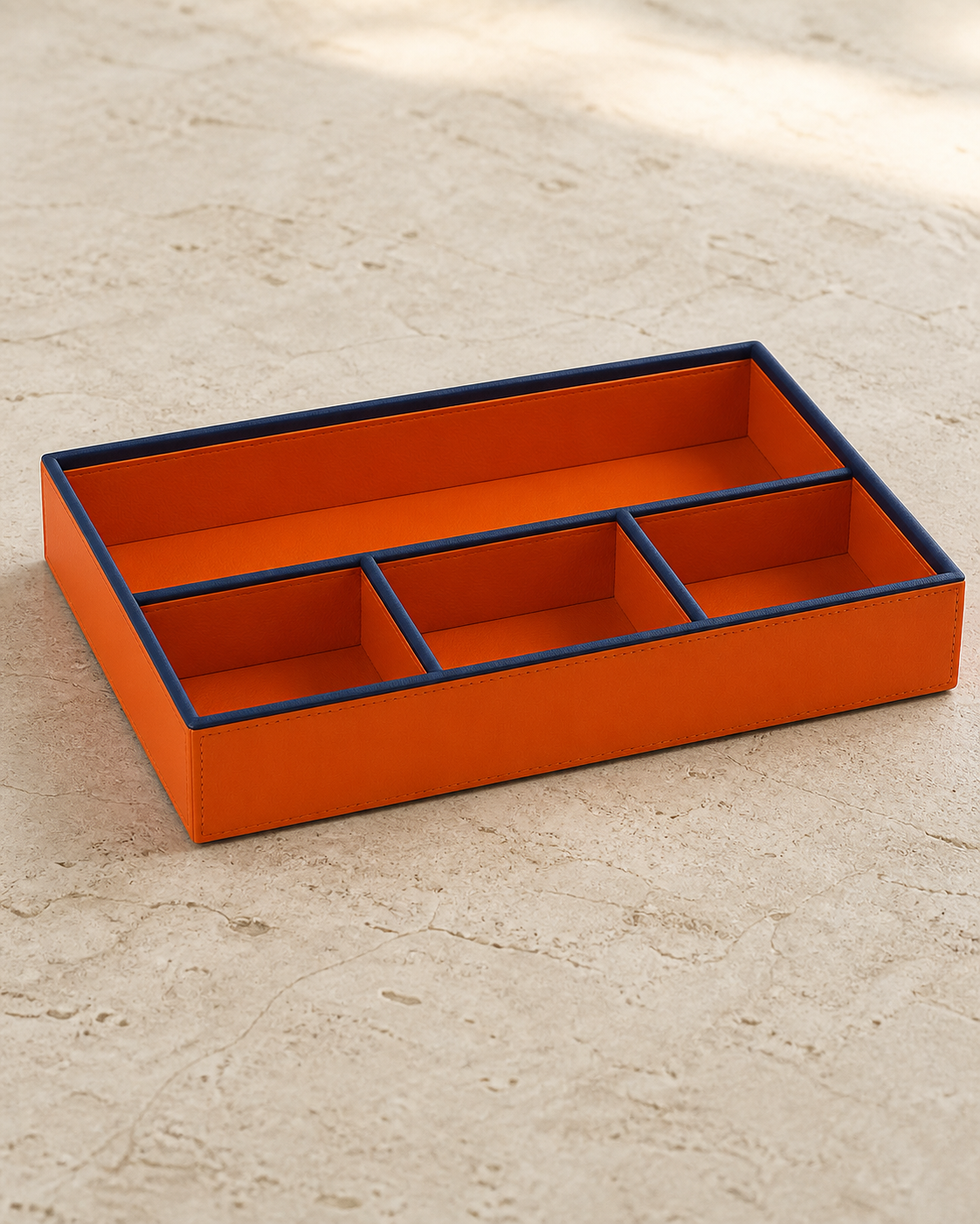 Orange compartment tray with blue piping, 4 compartments, grounded editorial view
