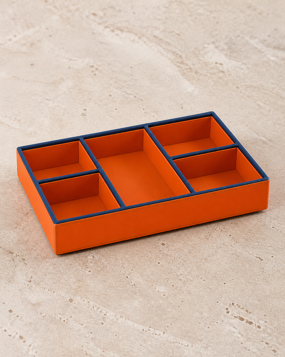 Orange compartment tray with blue piping, 5 compartments, grounded editorial view