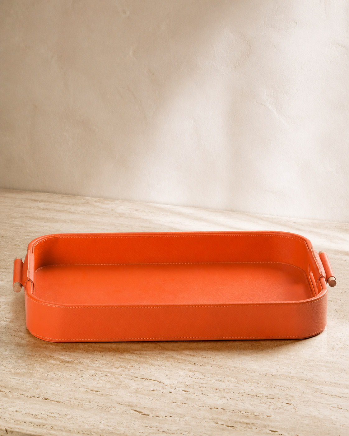 Orange serving tray with wooden handles, grounded editorial product view