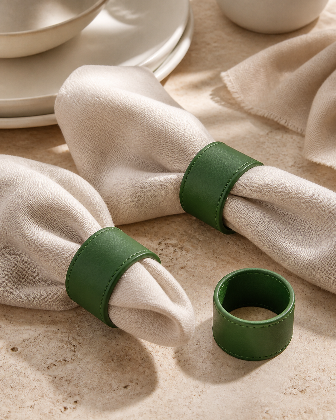 Green faux-leather napkin rings in editorial table setting